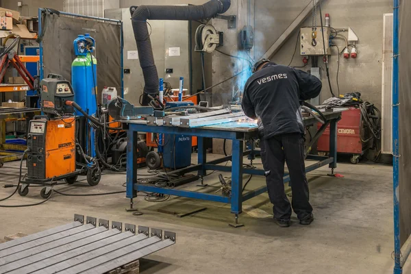 Worker welding at a workbench, Vesmes factory
